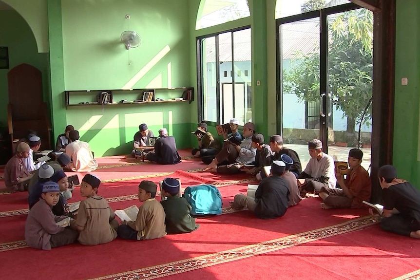 A group of young boy in a circle on the ground in Ibnu Mas'ud mosque