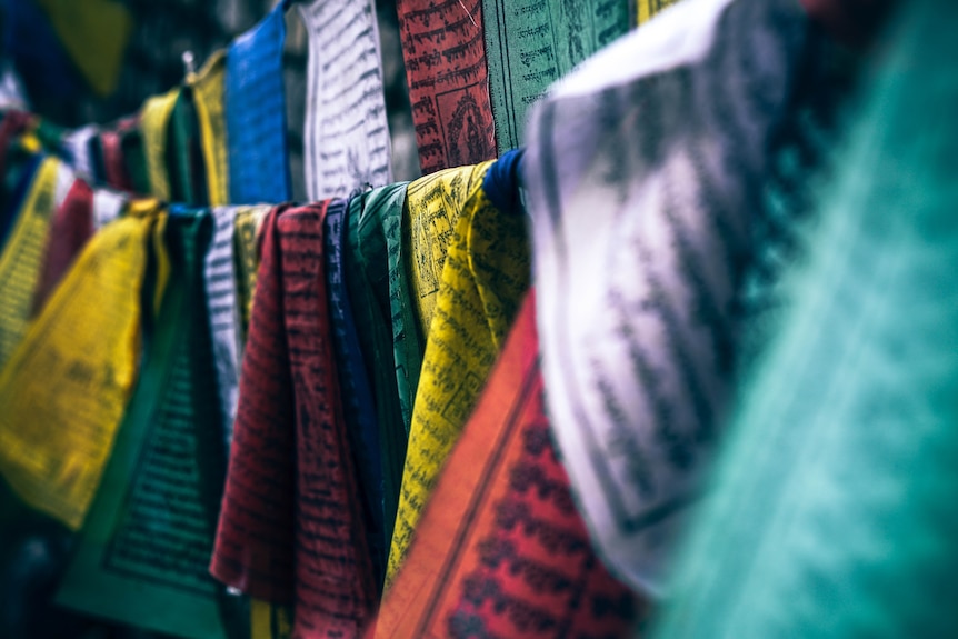 Colourful Tibetan prayer flags hang in a bunch