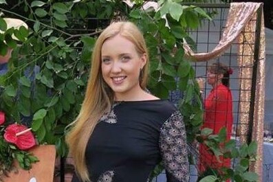 Jessica Hamill in a black dress smiles for a photograph