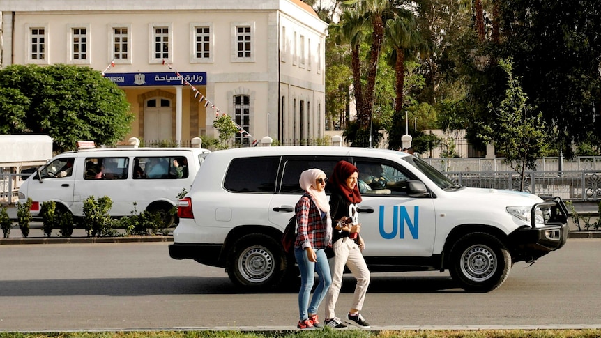 A four-wheel-drive vehicle with "UN" on the side drives along a street.