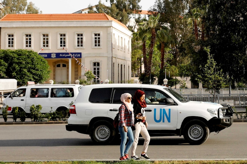 A four-wheel-drive vehicle with "UN" on the side drives along a street.