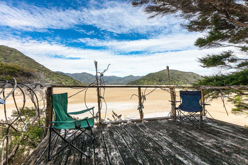 A deck and chairs on the Awaroa Bay beach