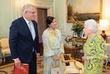 Queen wears bright yellow and blue pattern as she meets PM and his wife, PM holds a tartan patterned gift bag.