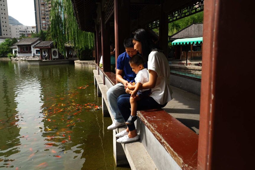Dandan Fan and her family feed the fish at a Beijing park.