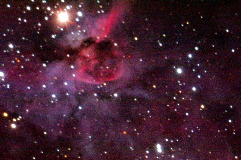 A combination of pink and purple colours with white stars scattered throughout space.