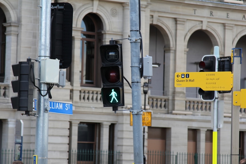 A green pedestrian flashing sign on a traffic light in Brisbane's CBD in June 2018.