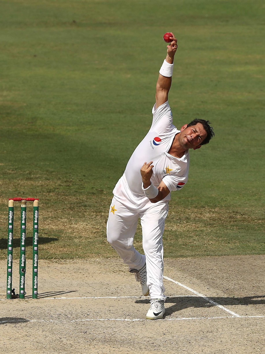 Telephoto shot of a man bowling a cricket ball.