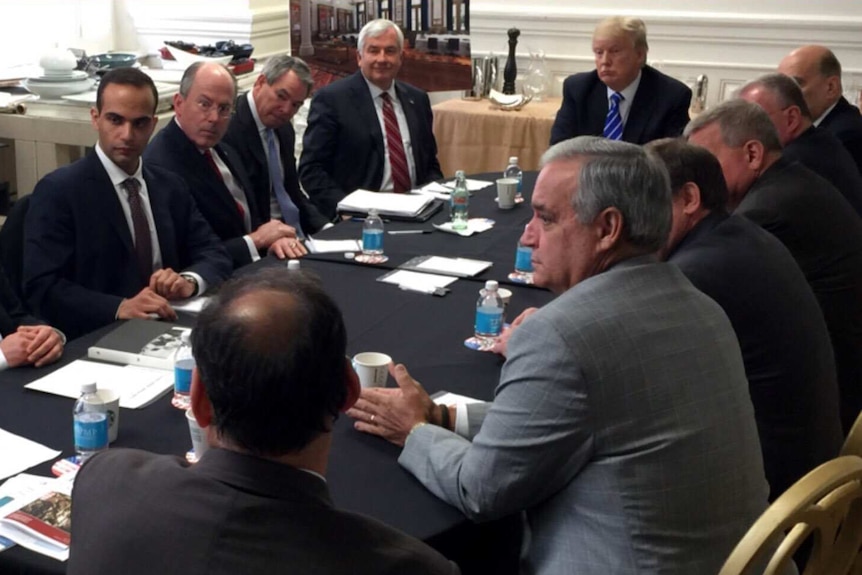 George Papadopoulos sits at a table with then-candidate Donald Trump