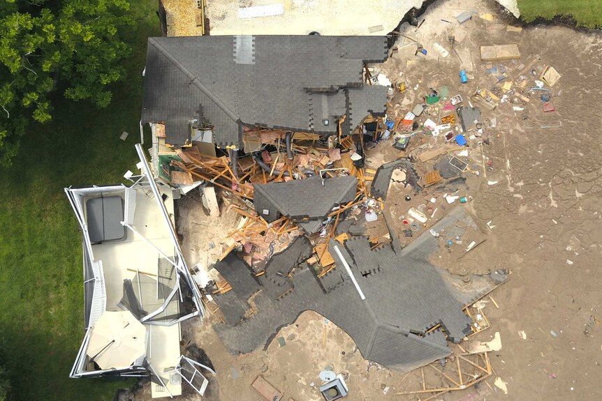 In this aerial photo, debris is strewn about after a sinkhole damaged two homes in Land O' Lakes