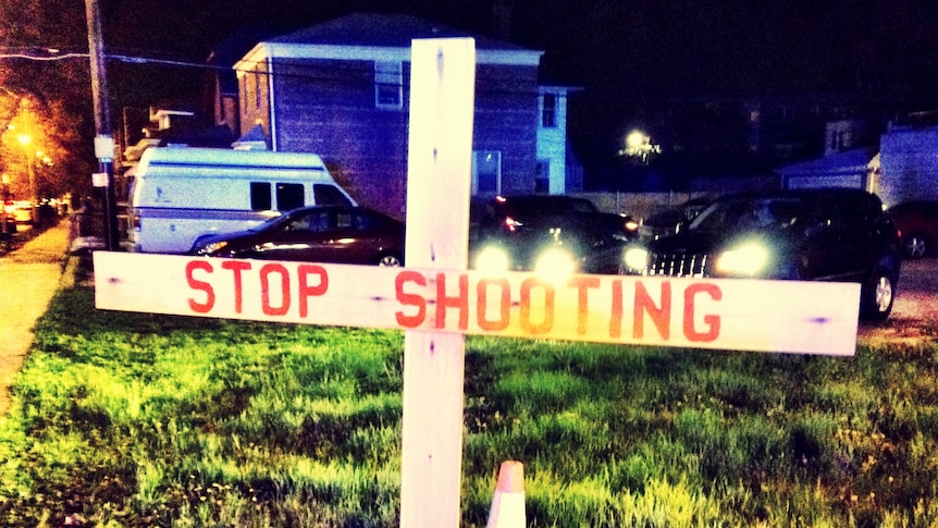A white cross with the words "Stop shooting" marks the site of the fatal shooting in Chicago.