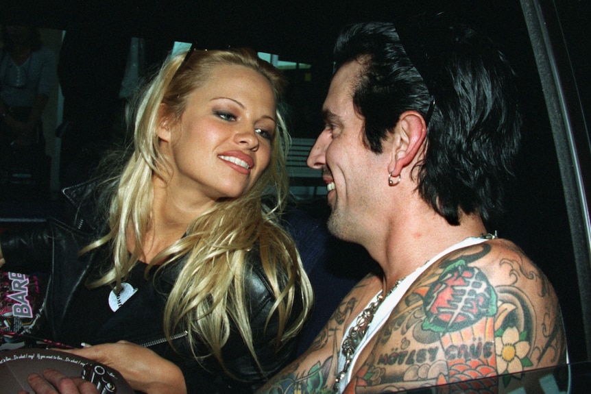 Pamela Anderson looks lovingly at Tommy Lee inside a car