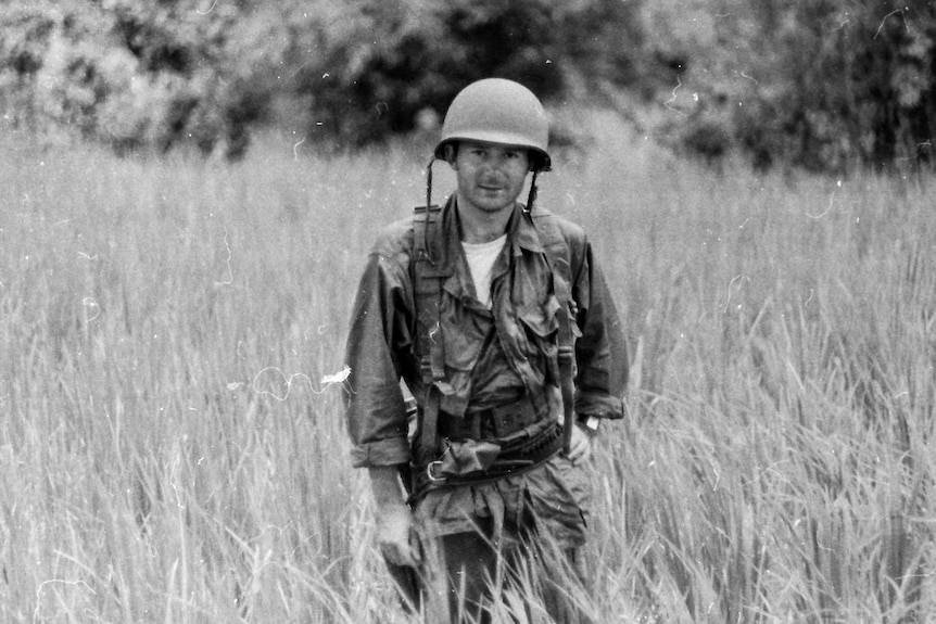 Derek Maitland standing in a field dressed in conflict apparel.