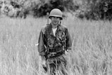 Derek Maitland standing in a field dressed in conflict apparel.
