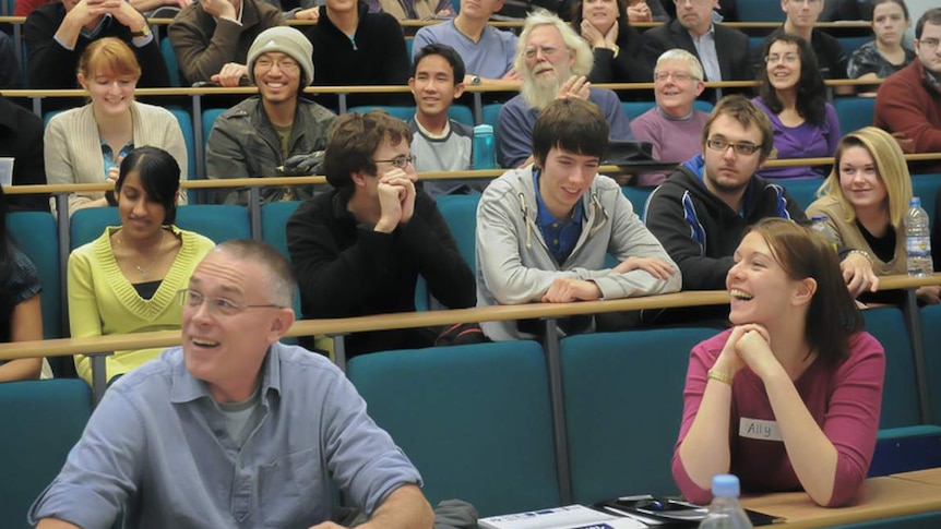 People of assorted ages are sitting in a lecture theatre.