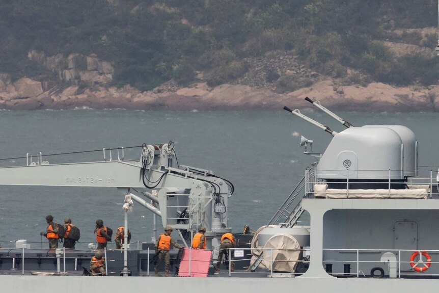 Soldiers stand on the deck of a Chinese warship as it sails during a military drill near Fuzhou