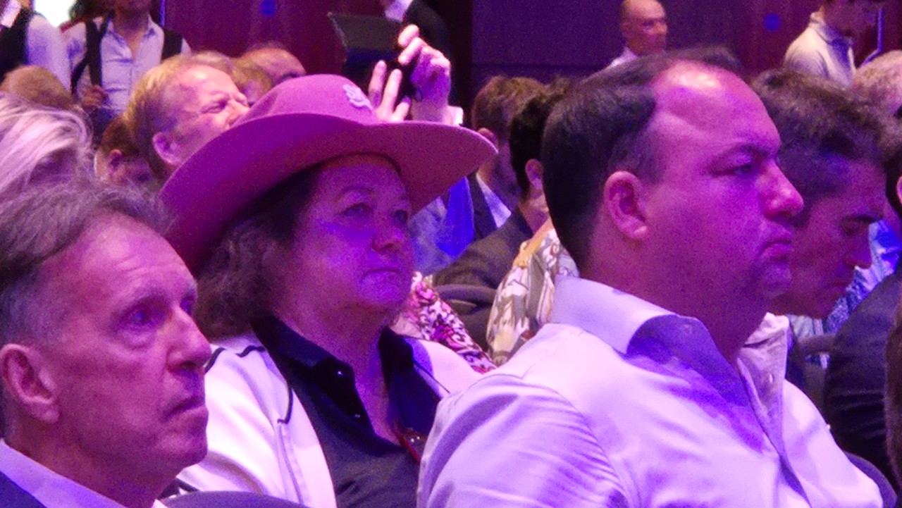Gina Rinehart, wearing a cowboy hat, sits in a crowd of people.