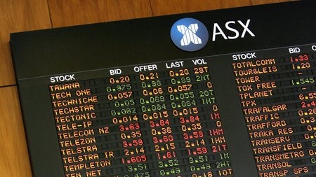 Investors watch the share price indicator board at the Australian Stock Exchange in Sydney.