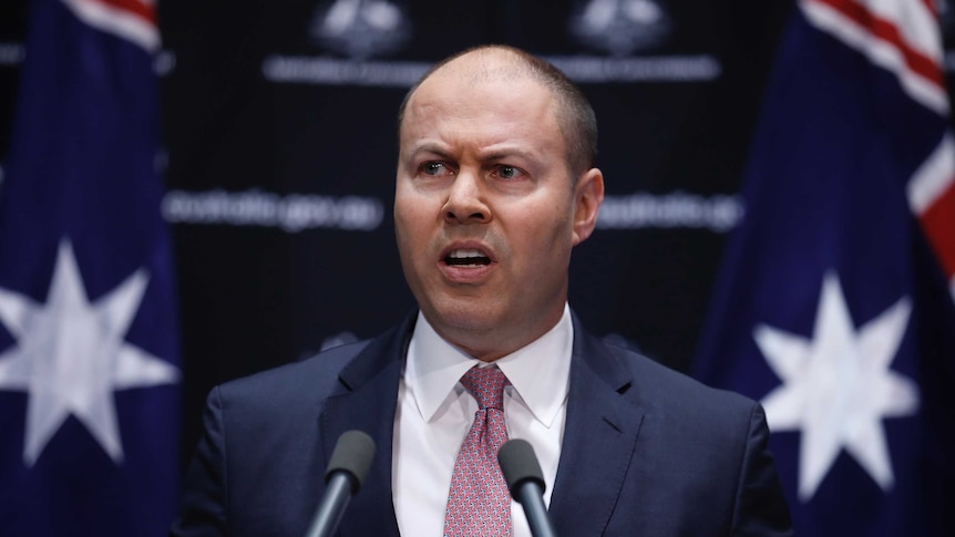 Josh Frydenberg speaks against a black background.