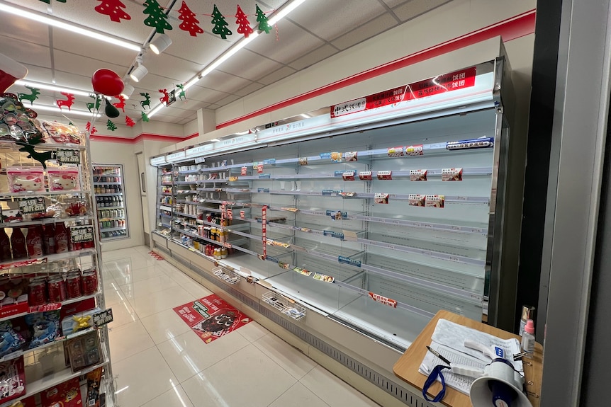 Supermarket shelves sit empty in the store.