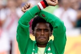 Ethiopia's Feyisa Lilesa crosses arms on marathon podium