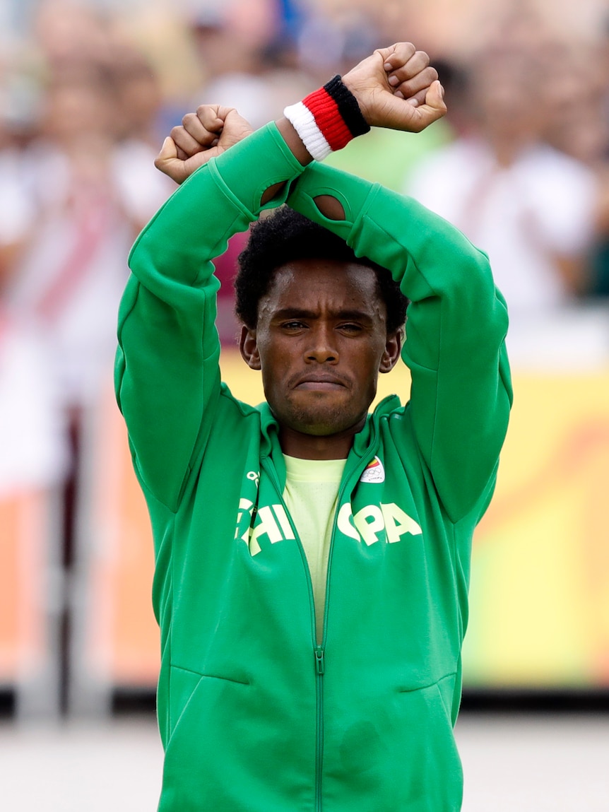 Ethiopia's Feyisa Lilesa crosses arms on marathon podium