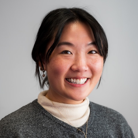 A woman with black hair smiles.
