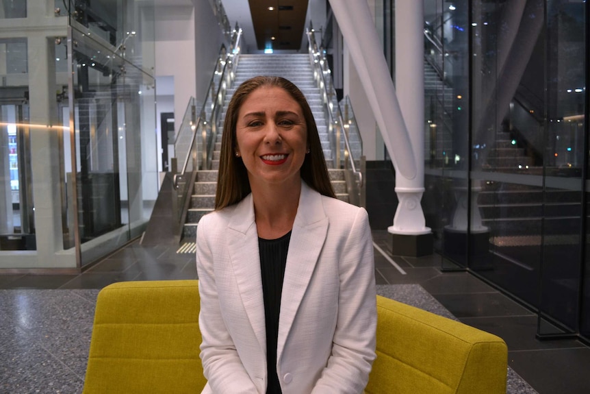 Associate Professor Prue Cormie smiles for the camera in an office buidling.