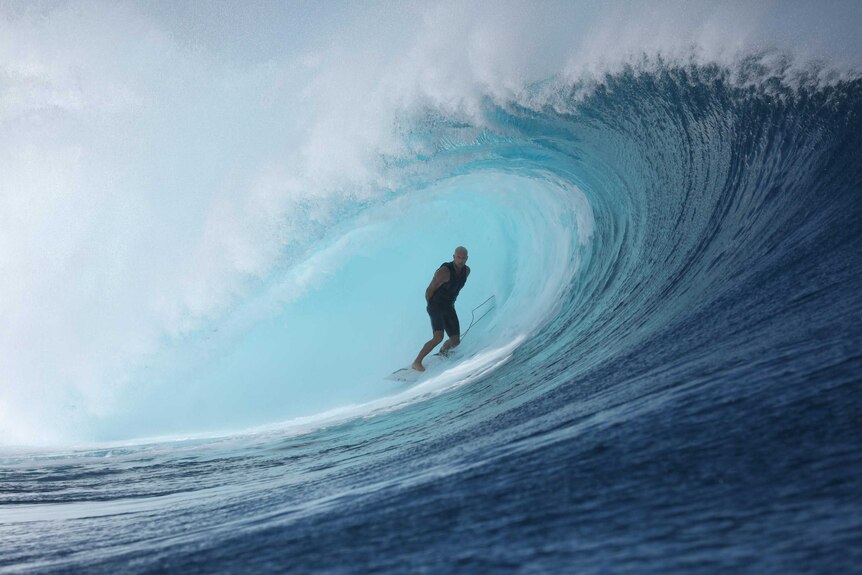 A man surfing a large wave for a story on taming dad rage
