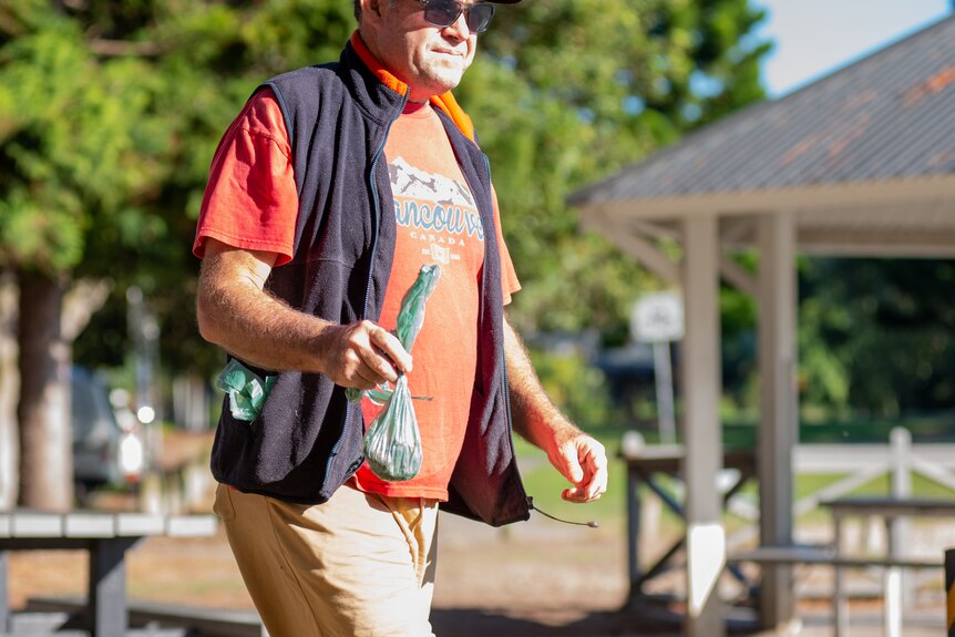 A man carrying a bag of dog poo.