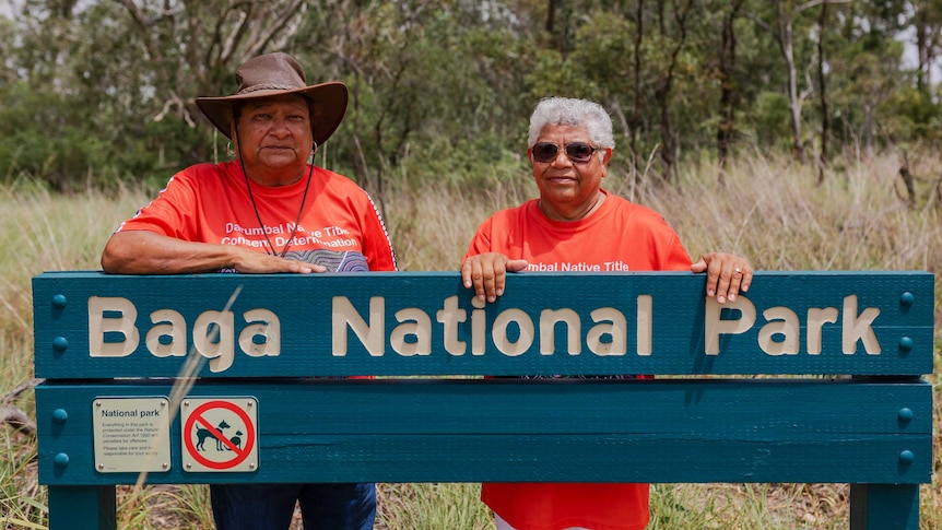 Aunty Sally Vea Vea, and Nhayla Nicky Hatfield standing behind Baga National Park sign in bush.