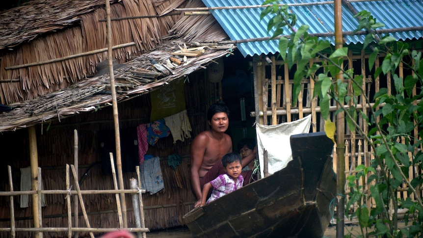 Resident commuting by boat through flooded water in Myanmar