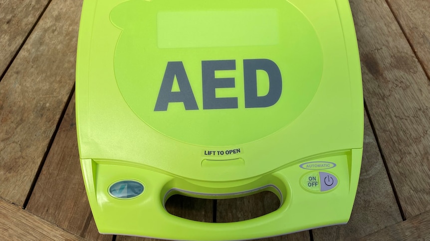 Fluro green defibrillator on wood table