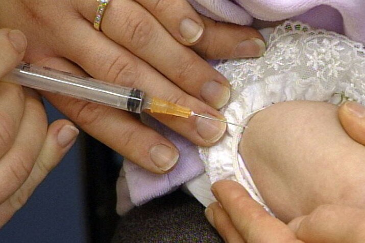 A child being vaccinated with a needle.