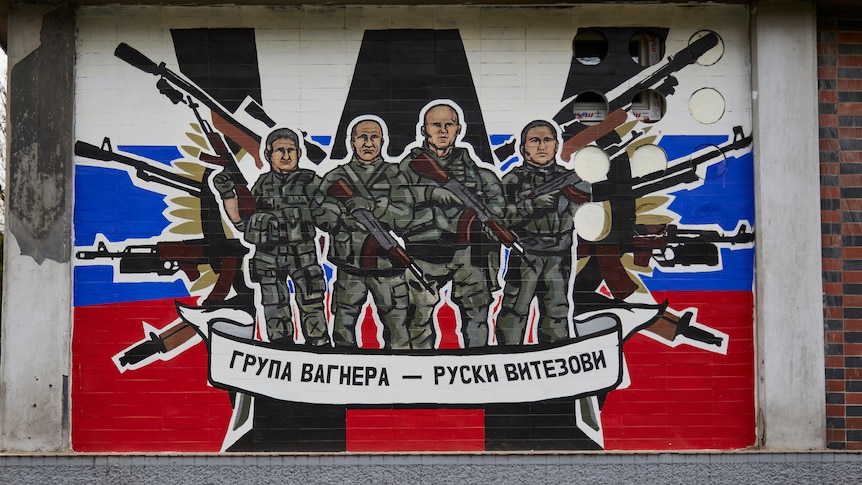 A mural with soldiers, guns and the Russian flag.