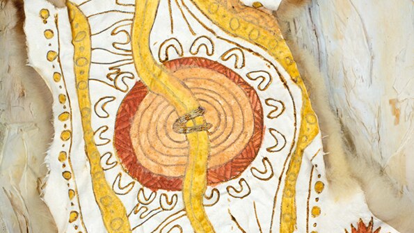 A possum-skin cloak with a yellow and brown Aboriginal art design.