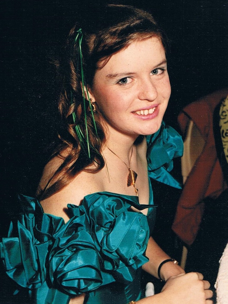 Teenage Nicola smiles at the camera, in a big blue 80s dress.