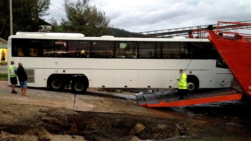 A bus sits stranded between land and the ferry it was trying to board.