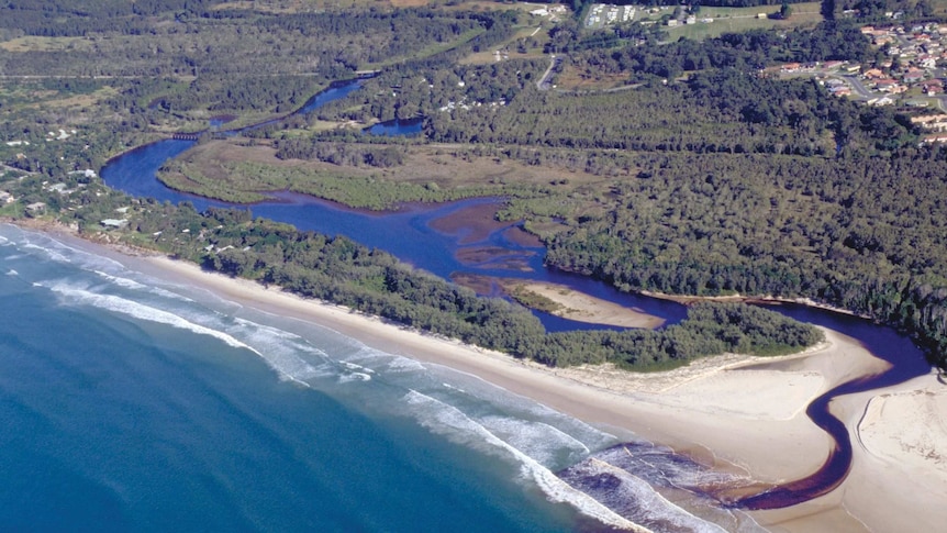 A tea coloured estuary winds its way through the landscape north of Byron Bay and empties into the ocean
