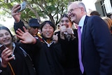 Anthony Albanse poses for a selfie with high school students