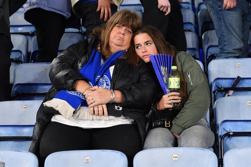 Two Leicester fans sit with glum looks on their faces