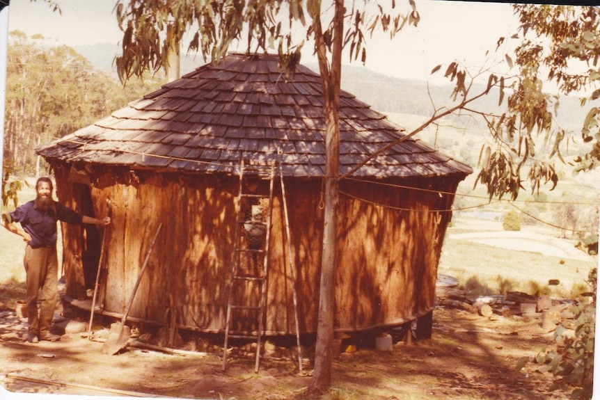 Fred Koch standing next to bark yurt dwelling