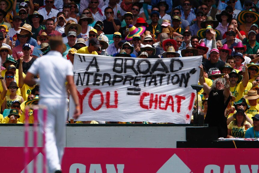 Australian fans hold up a banner about Stuart Broad as he walks at the SCG