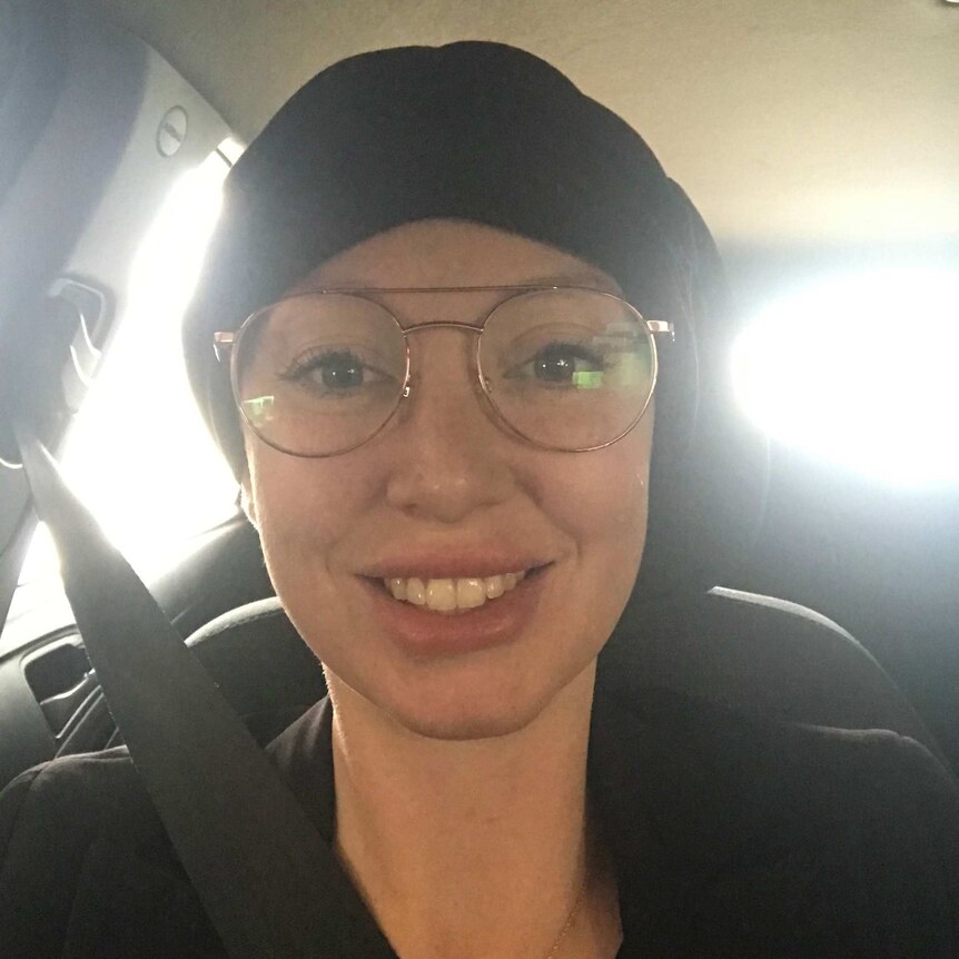 Elizabeth Pickworth sits in the car, posing in a selfie while wearing a beanie.