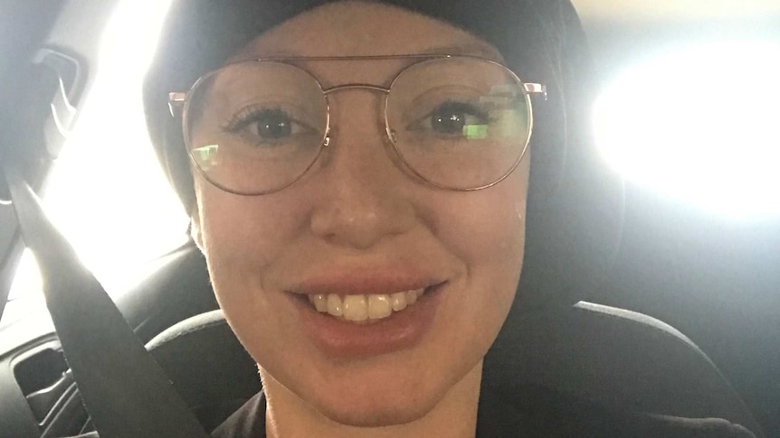 Elizabeth Pickworth sits in the car, posing in a selfie while wearing a beanie.