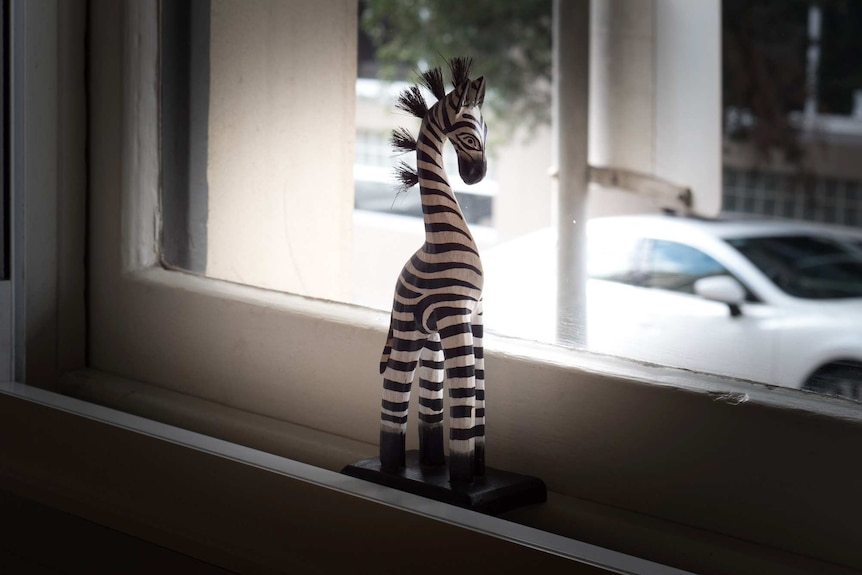 A zebra stature sits on a windowsill