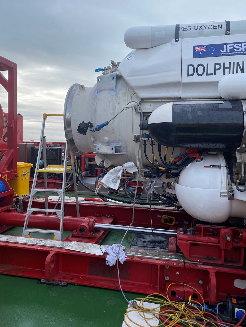 A submersible vessel sits on the deck of a boat