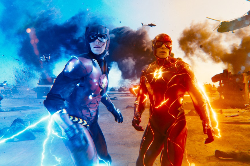 Two men dressed in superhero spandex costumes - one red, one blue - stand electrified and ready to fight.