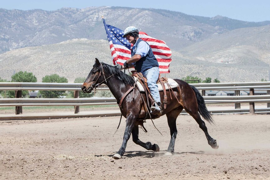 Man riding a horse with an American flag