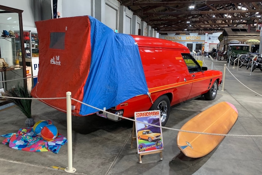 Red Sandman panel van with tail tent that expands out the back of the van.