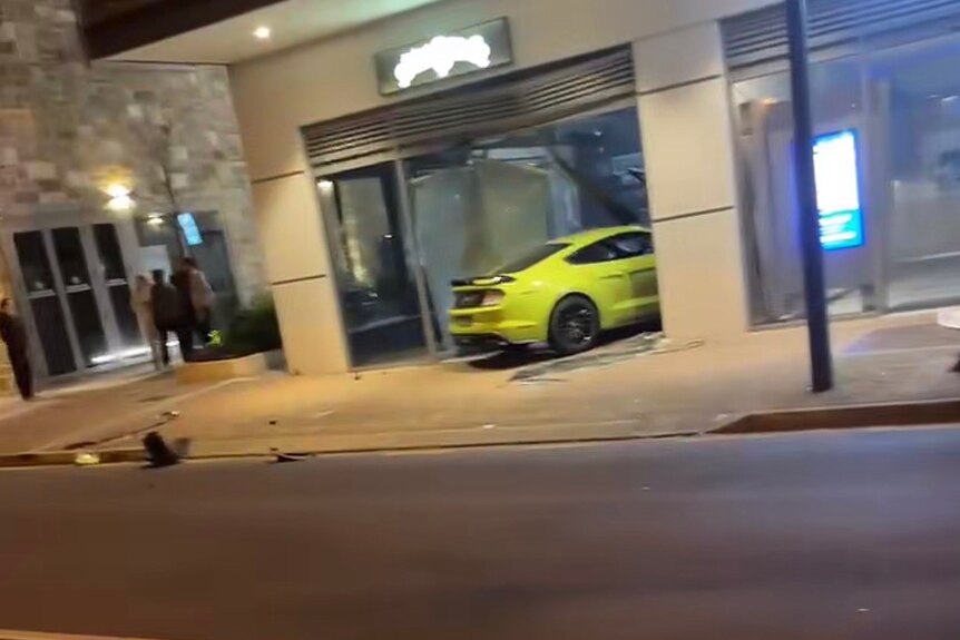 A lime green coloured mustang crashed through a window of a store front